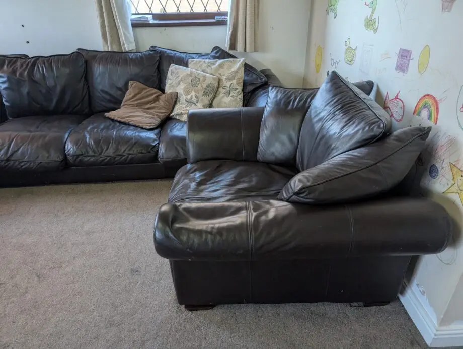 Black leather 5-6 seater sofa plus single sofa and large foot stool.