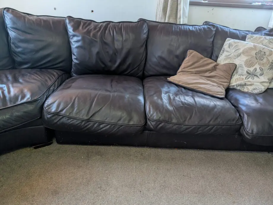Black leather 5-6 seater sofa plus single sofa and large foot stool.