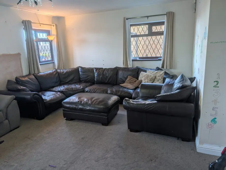 Black leather 5-6 seater sofa plus single sofa and large foot stool.