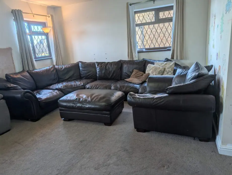 Black leather 5-6 seater sofa plus single sofa and large foot stool.