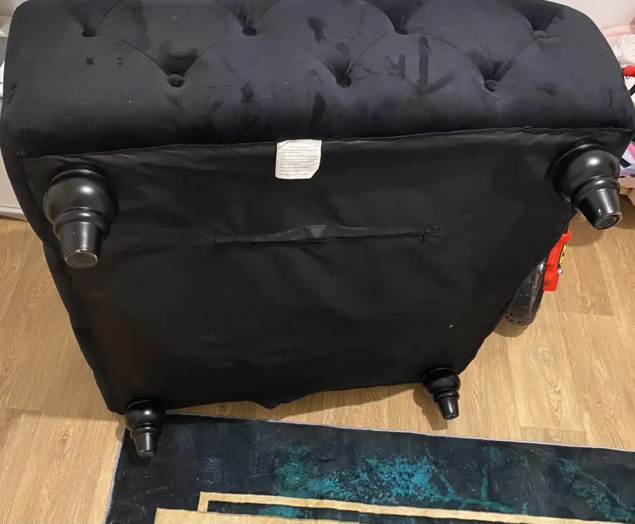 Black velvet upholstered ottoman