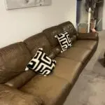 Brown leather sofa with recliner seat and footstool