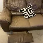 Brown leather sofa with recliner seat and footstool