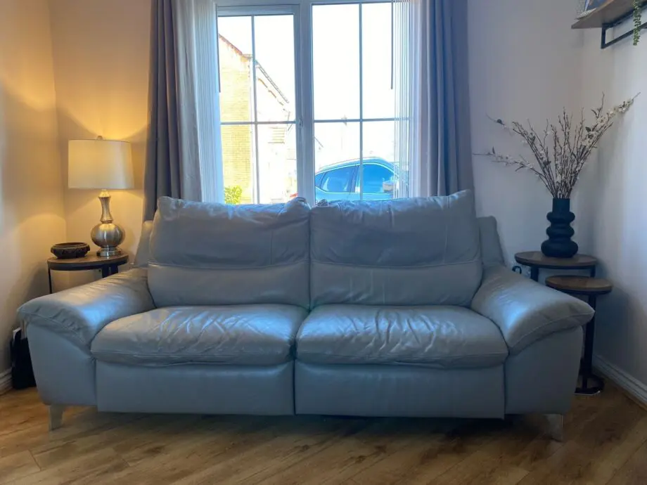 Light grey leather reclining sofa.