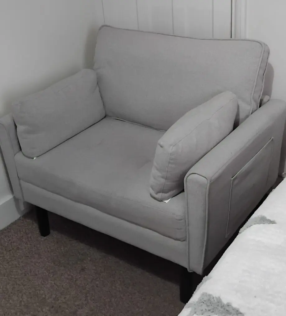 A grey arm chair with a weight capacity of 136kg