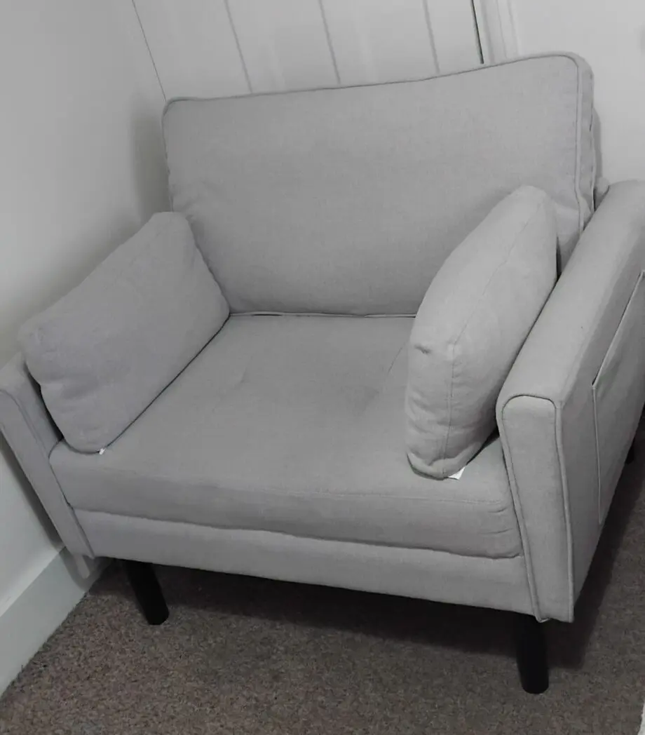 A grey arm chair with a weight capacity of 136kg
