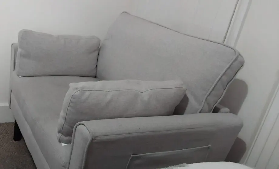 A grey arm chair with a weight capacity of 136kg