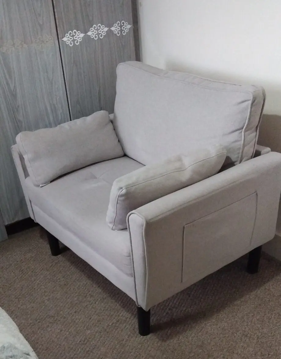 A grey arm chair with a weight capacity of 136kg