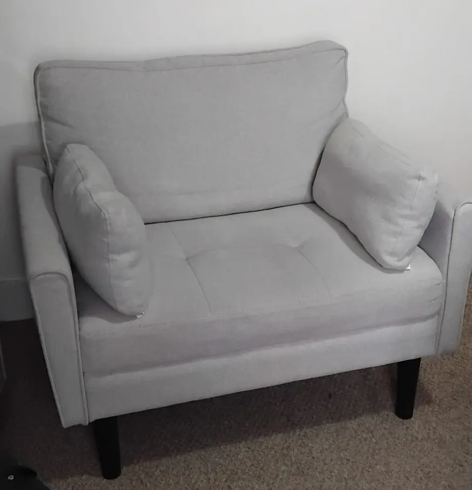 A grey arm chair with a weight capacity of 136kg