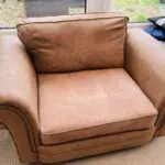 Tan leather effect cuddle chair.