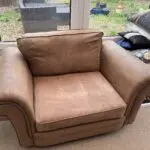 Tan leather effect cuddle chair.