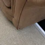 Tan leather effect cuddle chair.