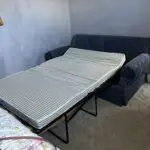 Deep blue sofa bed with footstool