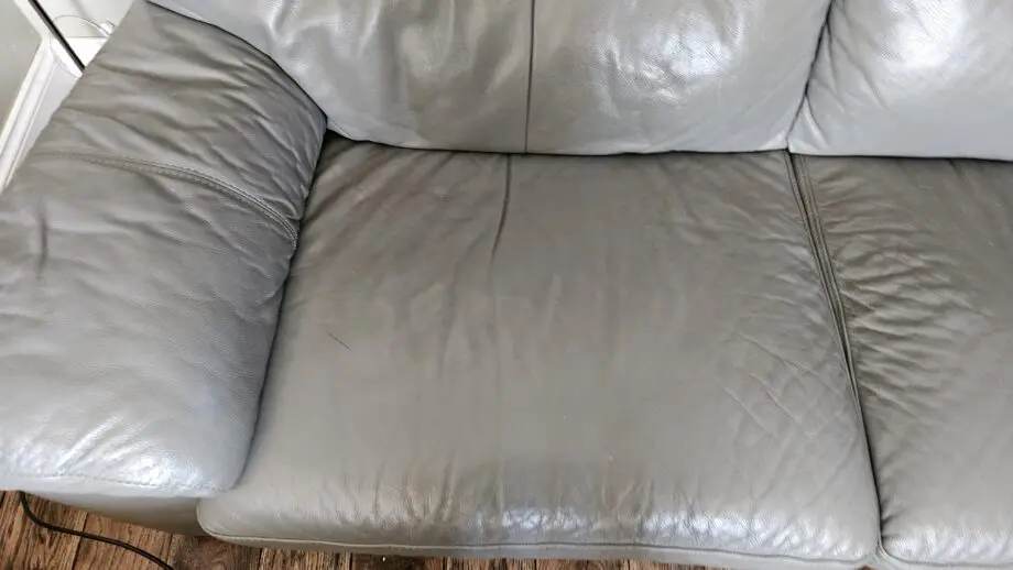 2 Grey leather 2 seater sofas with poof