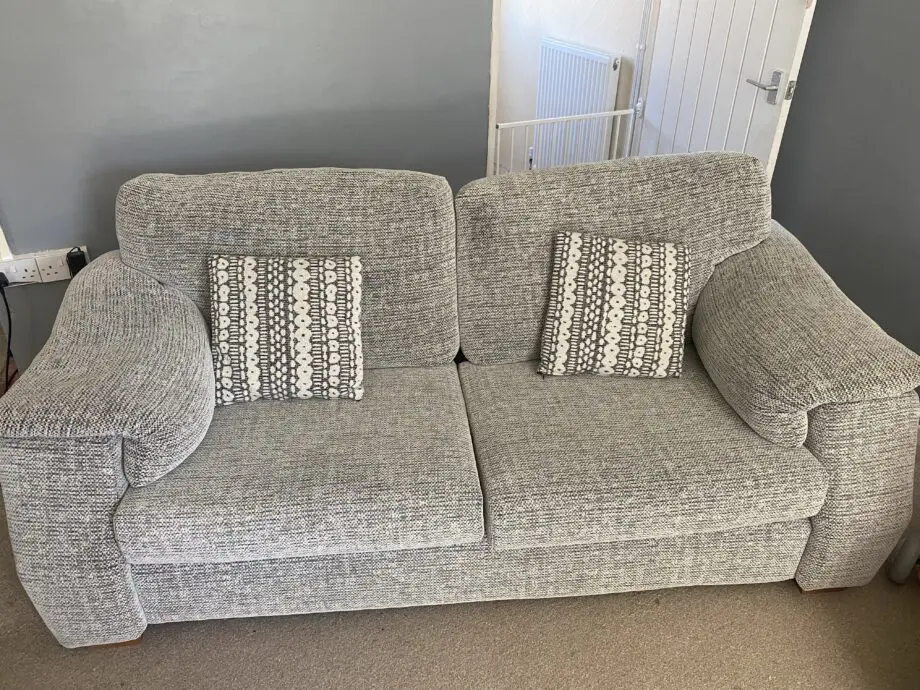 Two 3 seater grey speckled sofas and footstool