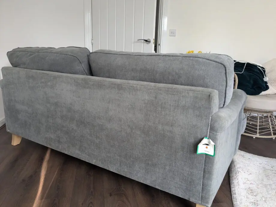 Grey sofa with removable covers and wood spindle legs. Lovely sofa and very comfortable.