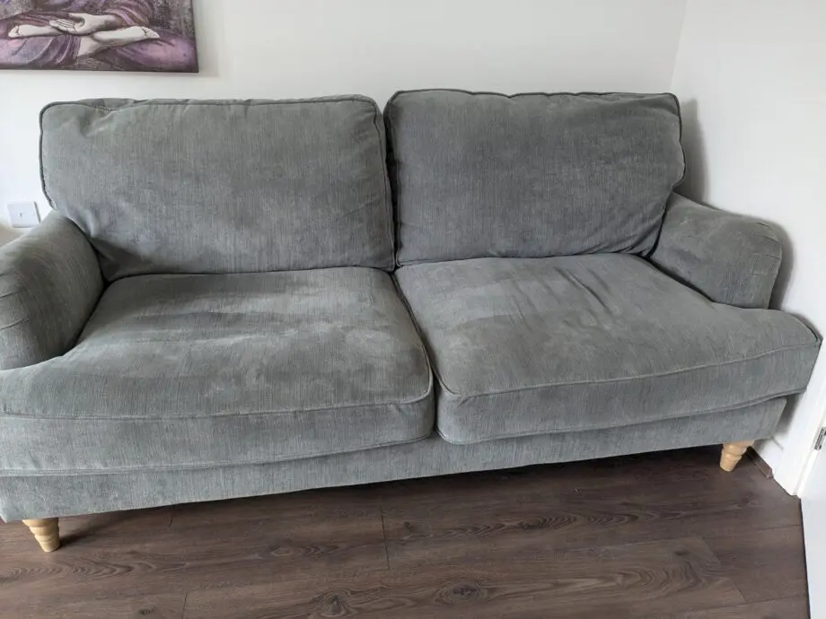 Grey sofa with removable covers and wood spindle legs. Lovely sofa and very comfortable.