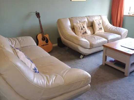 Two 2-seater cream leather sofas
