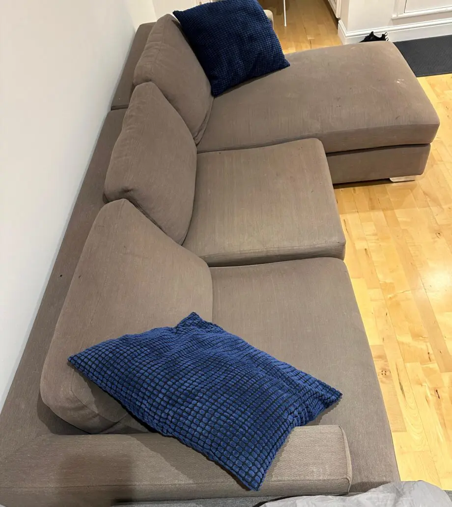 L-shaped brown fabrics sofa with blue cushions
