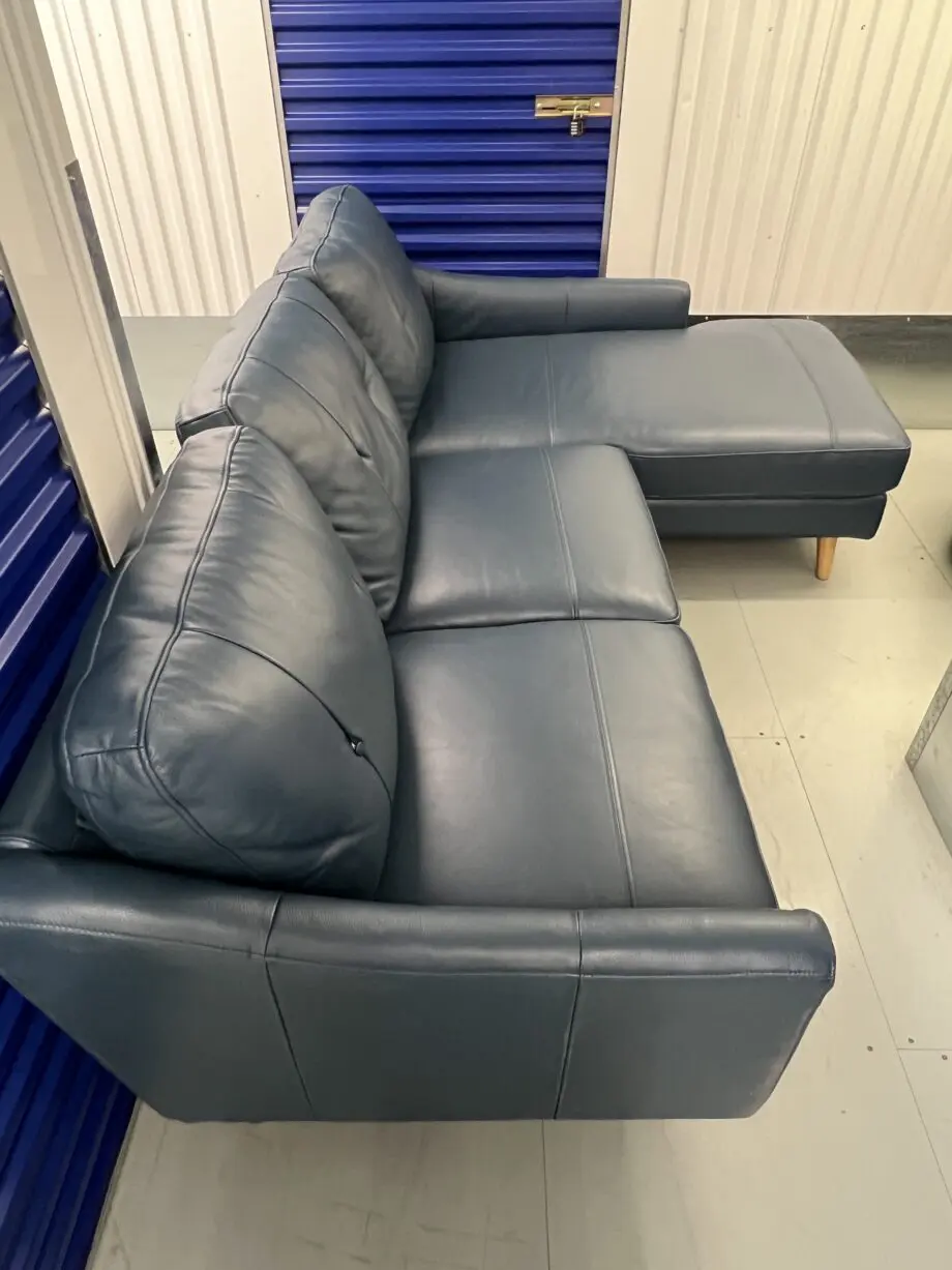 Blue leather sofa and matching footstool