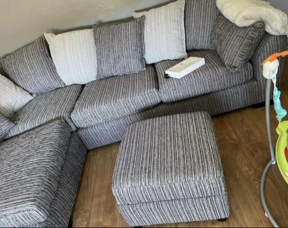DFS grey/black l-shaped couch with matching footstool also