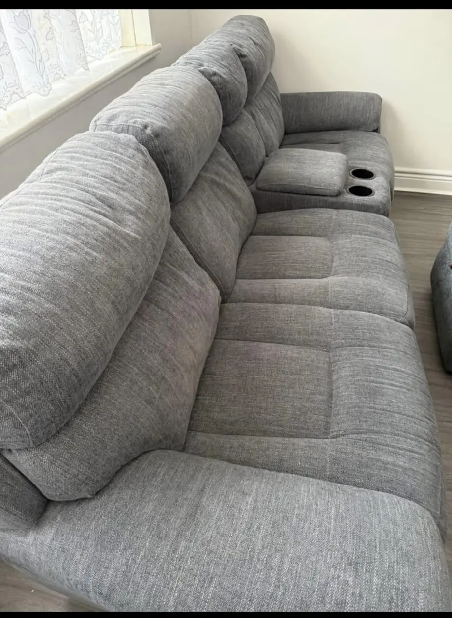 Grey sofa with recliner seats each side; middle cupholder and footstall