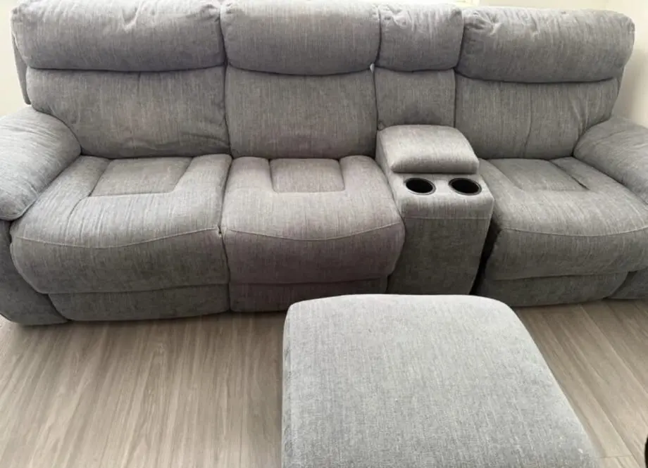 Grey sofa with recliner seats each side; middle cupholder and footstall