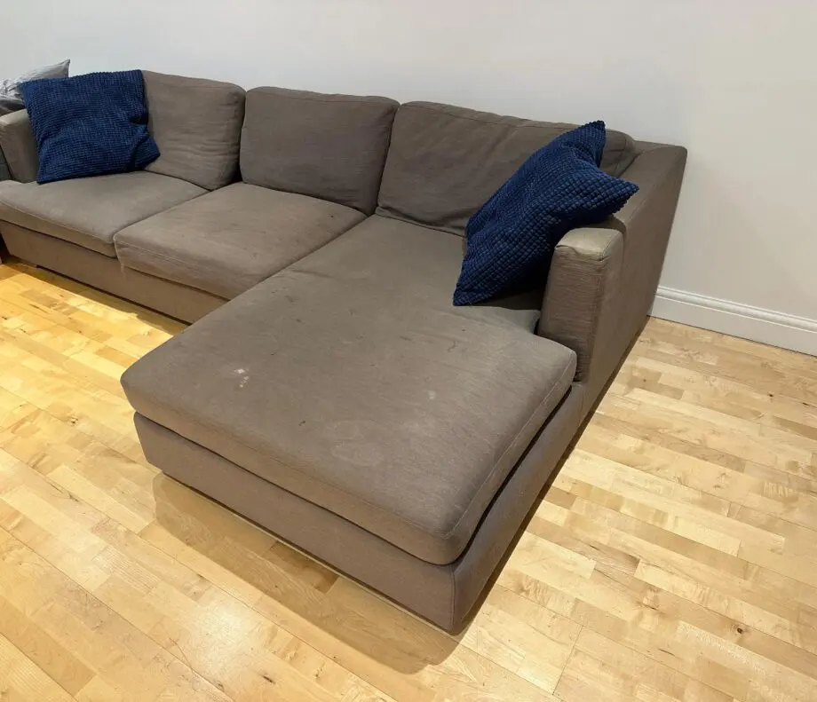 L-shaped brown fabrics sofa with blue cushions