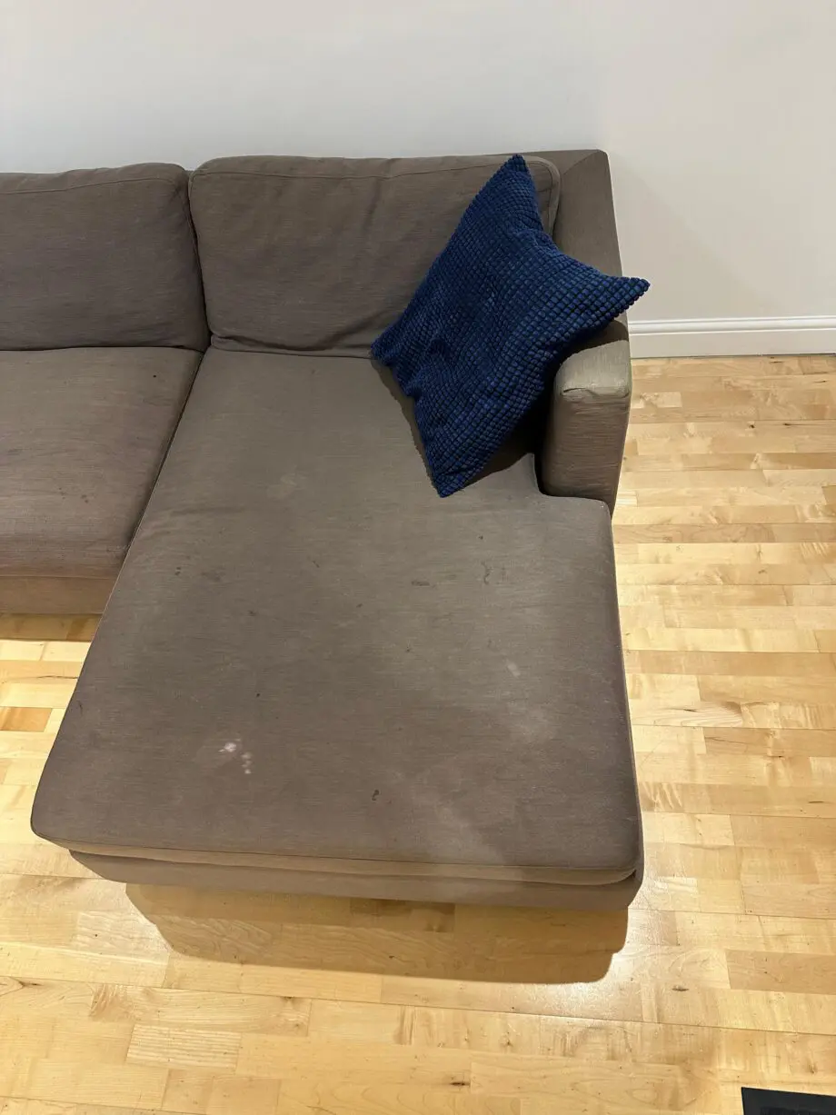 L-shaped brown fabrics sofa with blue cushions