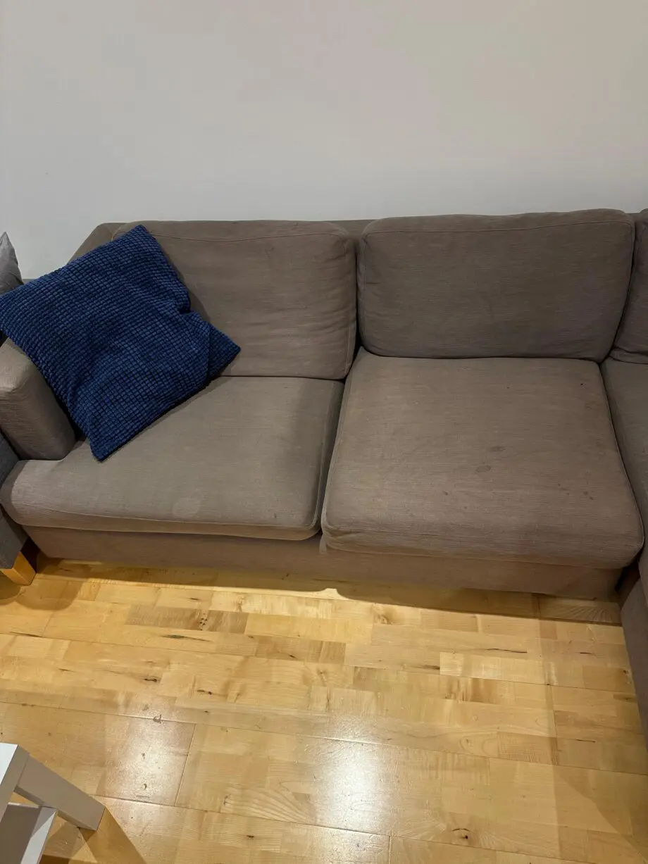 L-shaped brown fabrics sofa with blue cushions