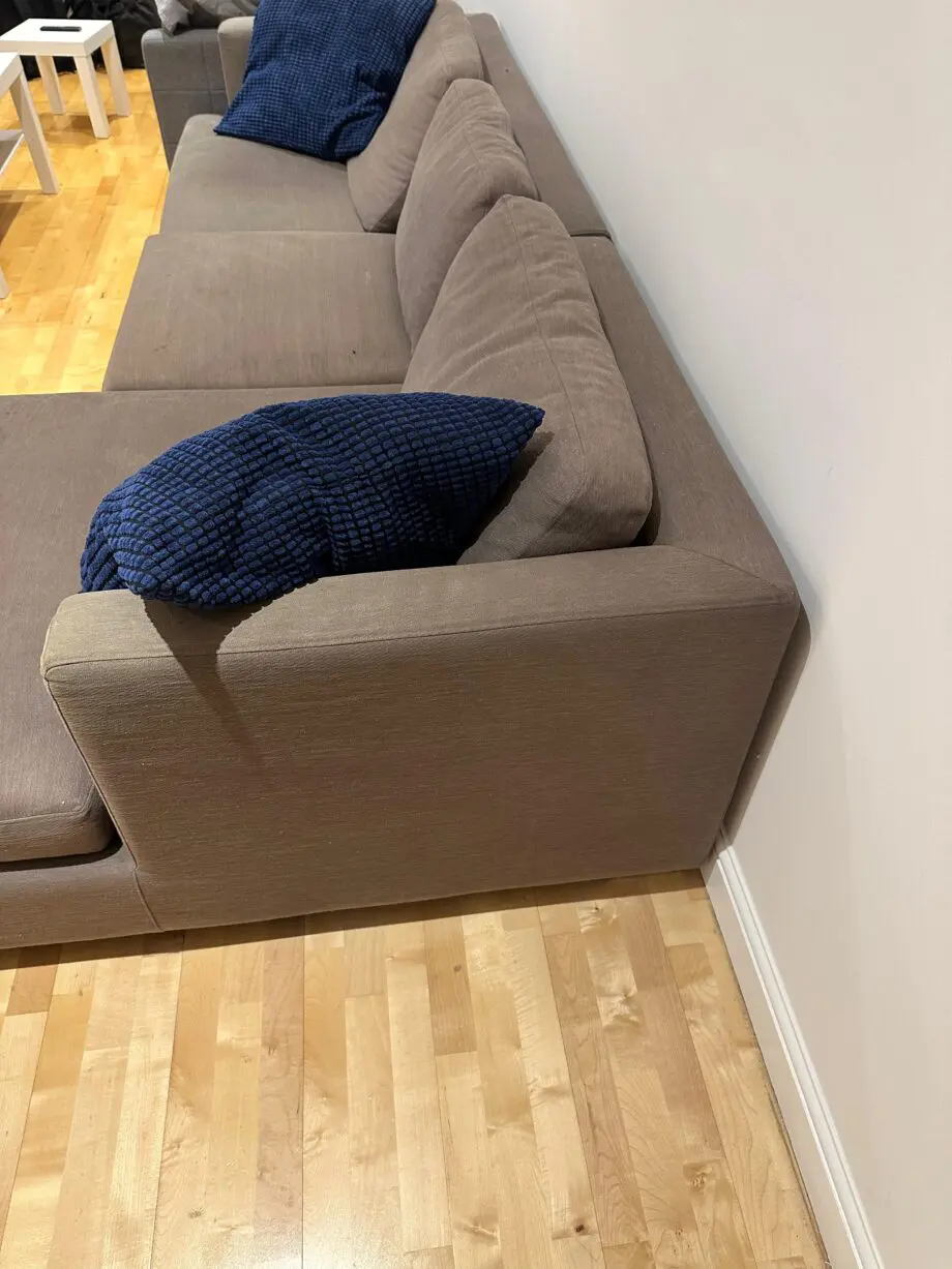 L-shaped brown fabrics sofa with blue cushions