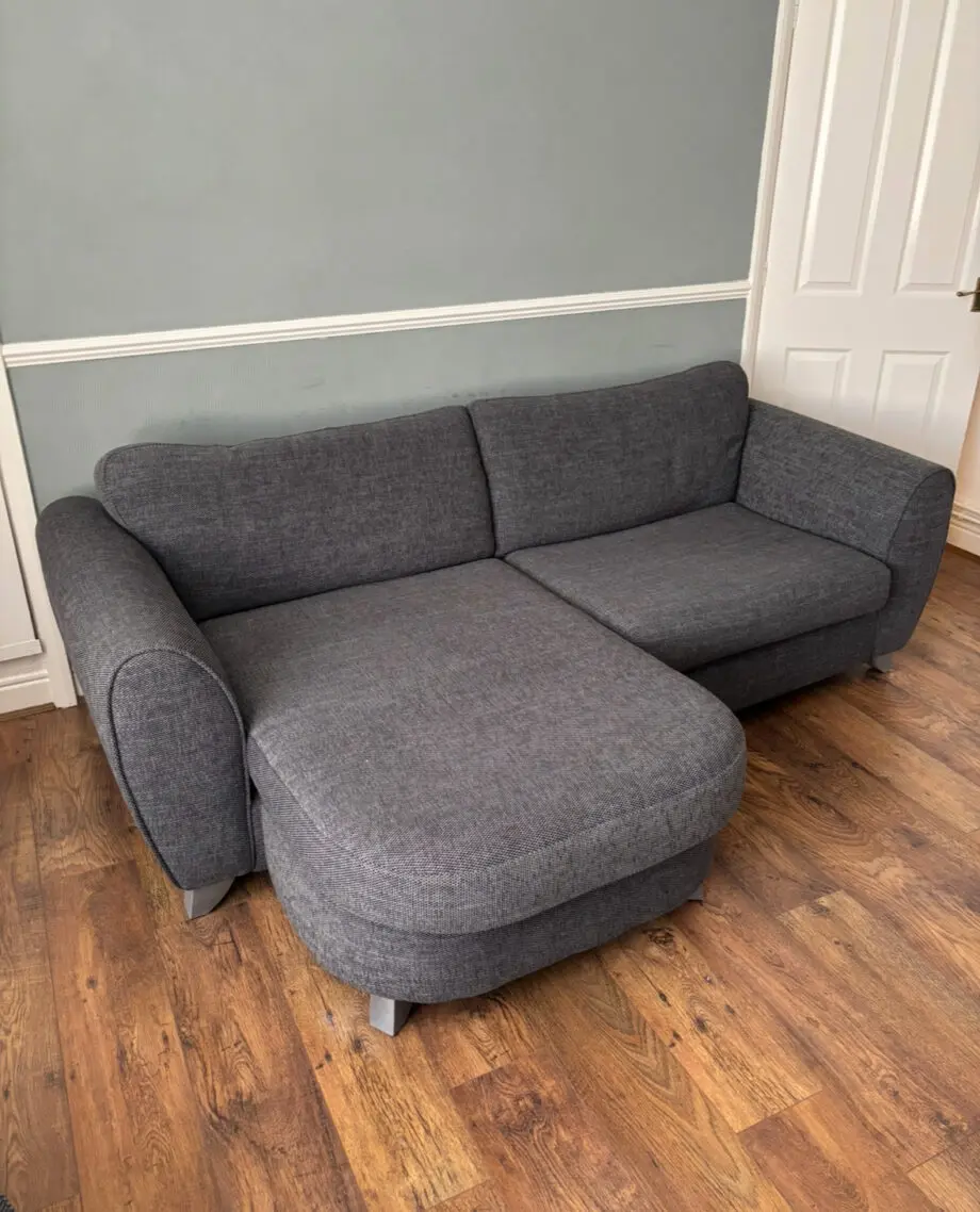 Grey settee with a lounge cushion and stool