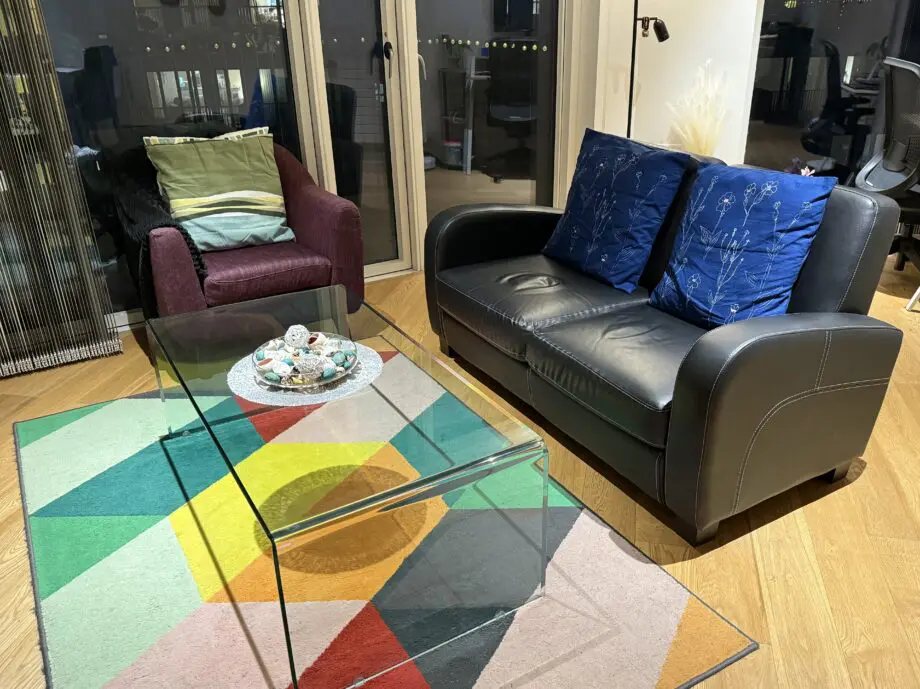 David Phillips black double seater sofa and purple corner sofa