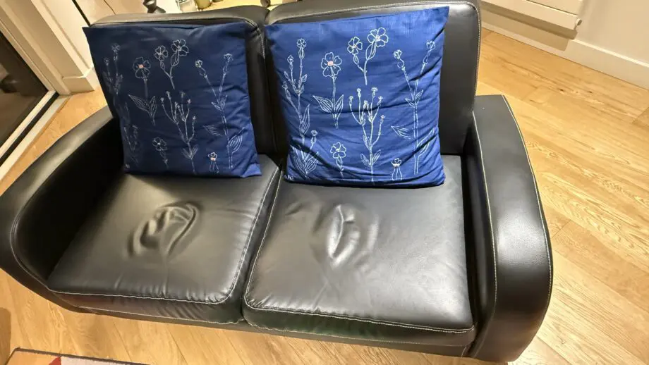 David Phillips black double seater sofa and purple corner sofa