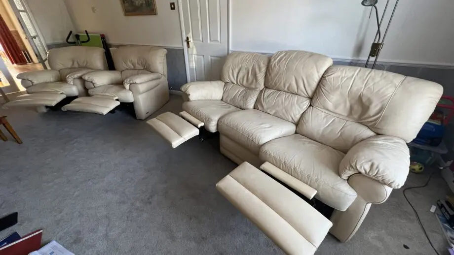 Two ivory leather manual recliner chairs and 3 seat manual recliner sofa with two recliners