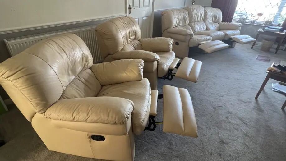 Two ivory leather manual recliner chairs and 3 seat manual recliner sofa with two recliners