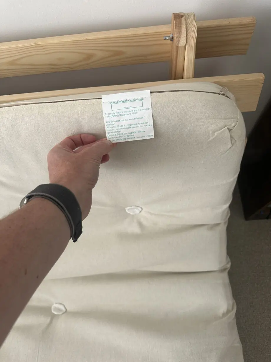 2 person Futon style sofa bed. Wooden frame and cream fabric cushion.