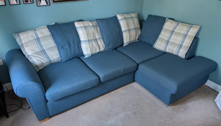 Navy blue corner sofa with scatter cushion back