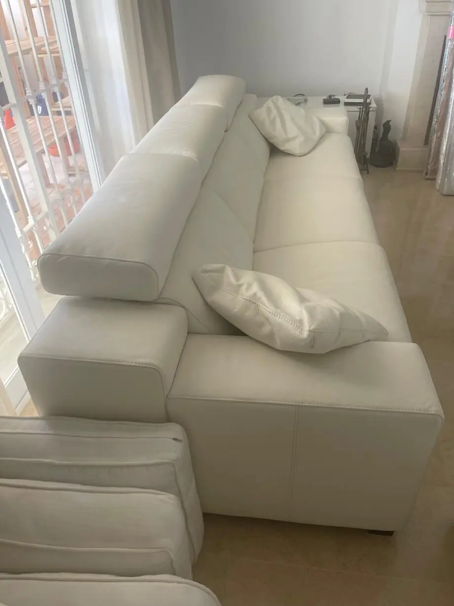 Two white leather three-seater sofas and matching reclining armchair