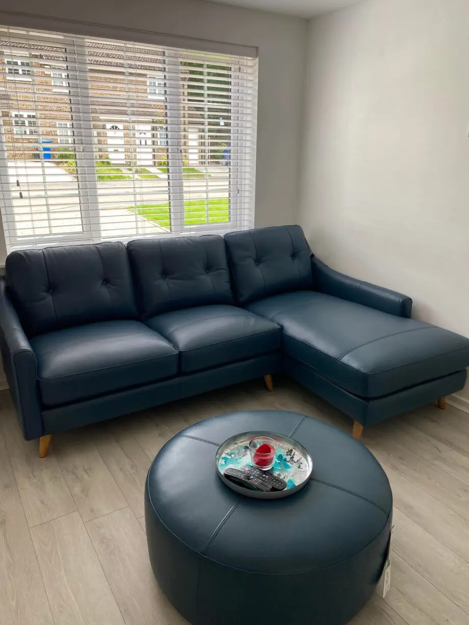 Blue leather sofa and matching footstool
