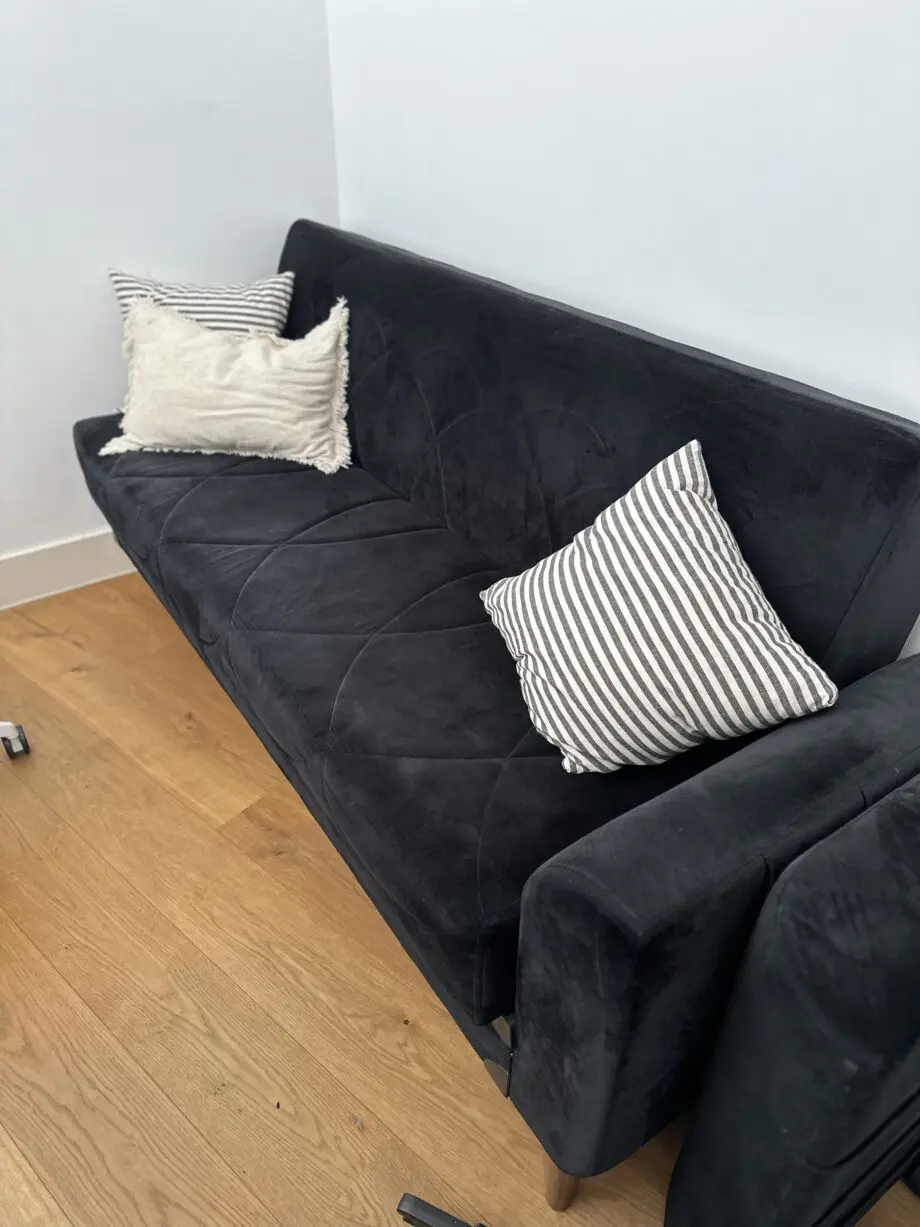 Comfortable and well-maintained 3-seater black sofa bed.