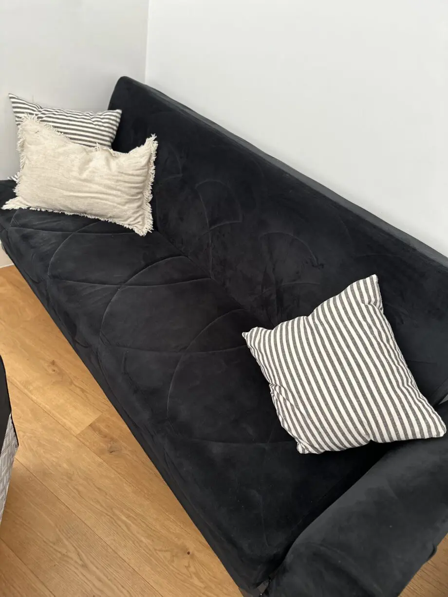 Comfortable and well-maintained 3-seater black sofa bed.