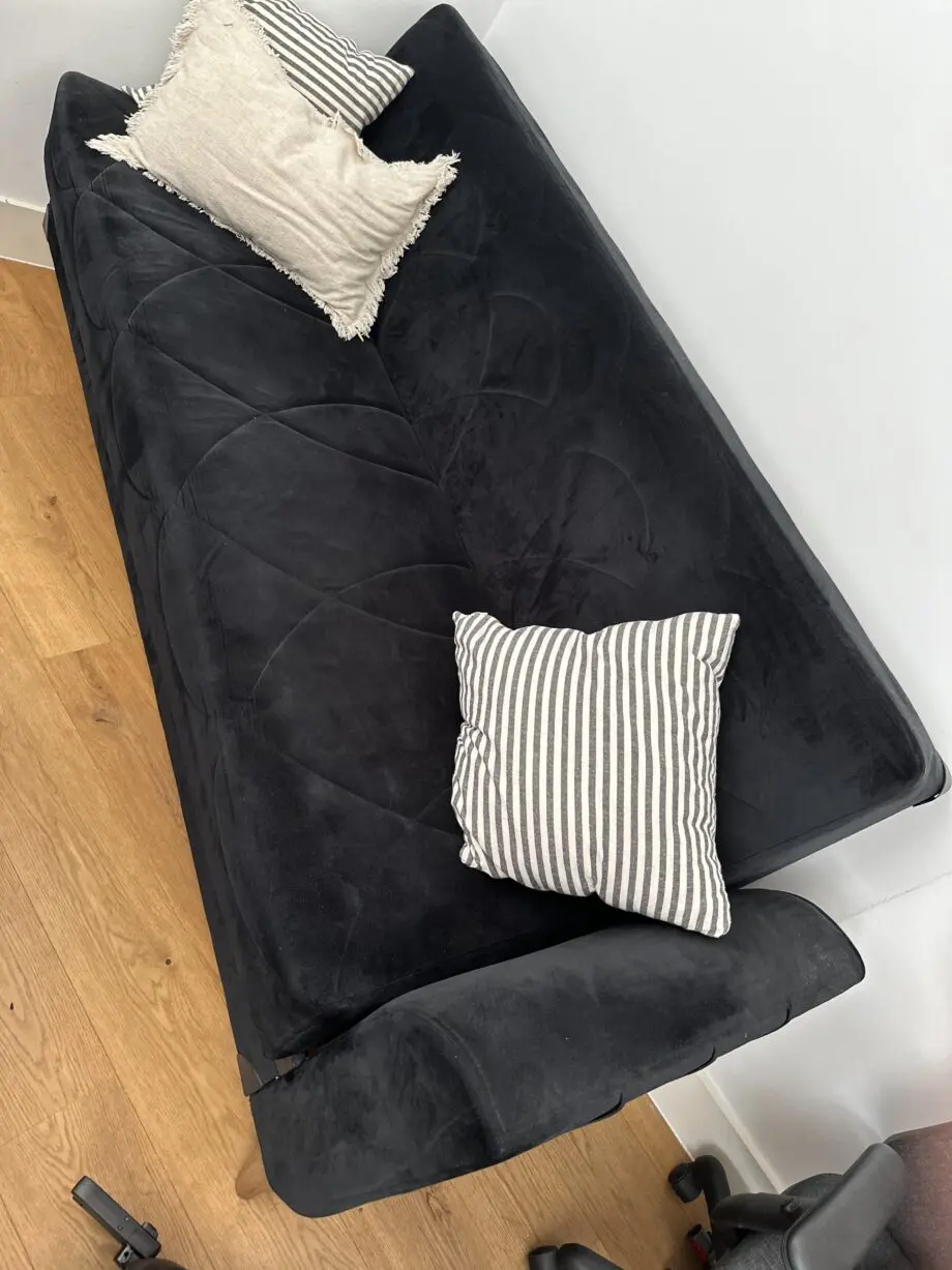 Comfortable and well-maintained 3-seater black sofa bed.