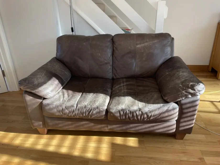 DFS - Distressed brown leather matching sofas.
