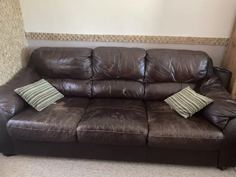 2 x dark brown leather sofa, well used but have some life. Would be ideal for a out building. One sofa has a very small ri0