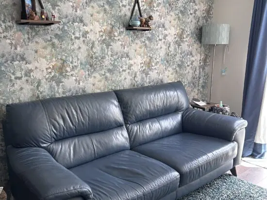 DFS denim blue leather, 3 seater sofa, with 5 dark wood legs.