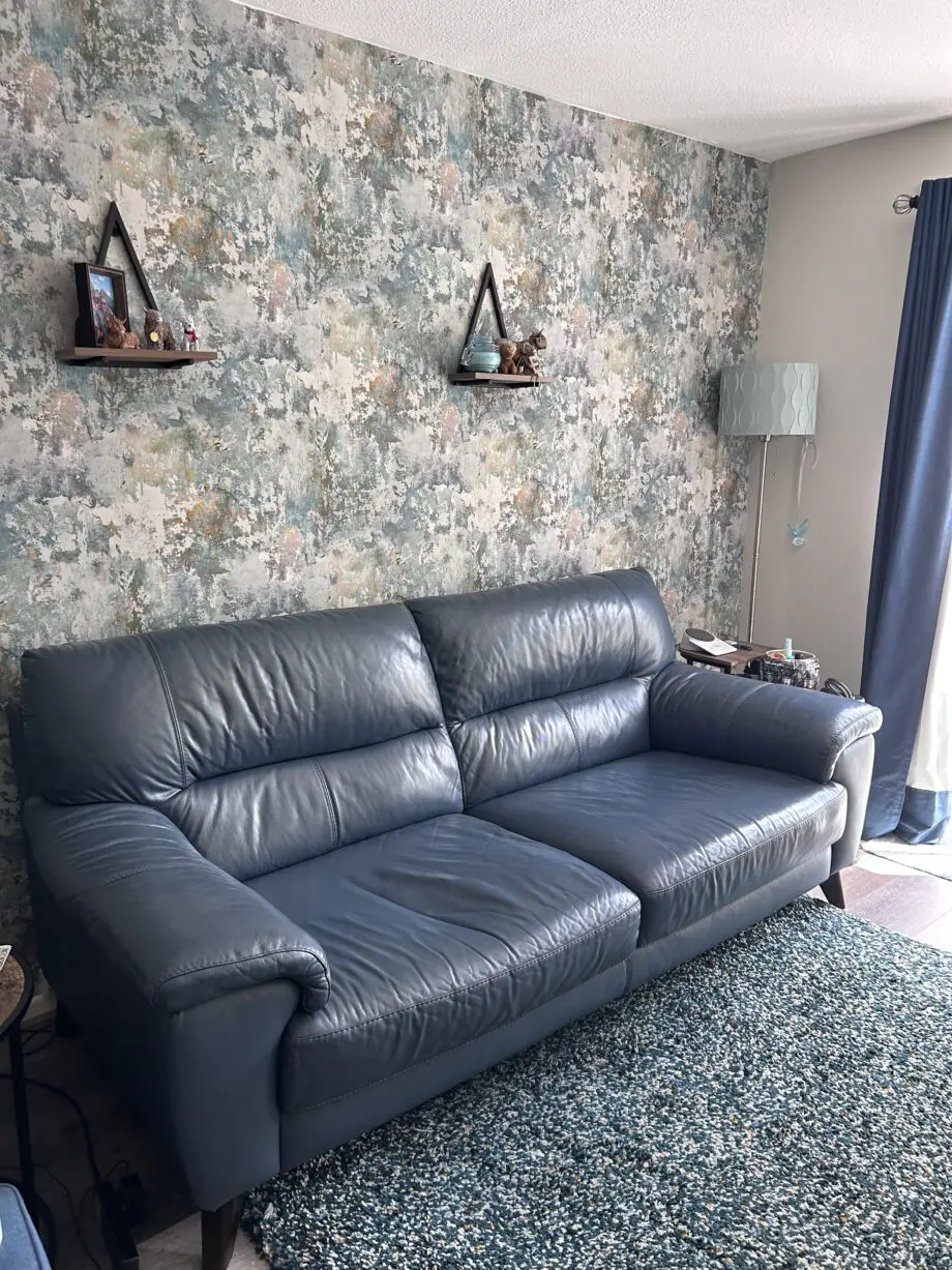 DFS denim blue leather, 3 seater sofa, with 5 dark wood legs.