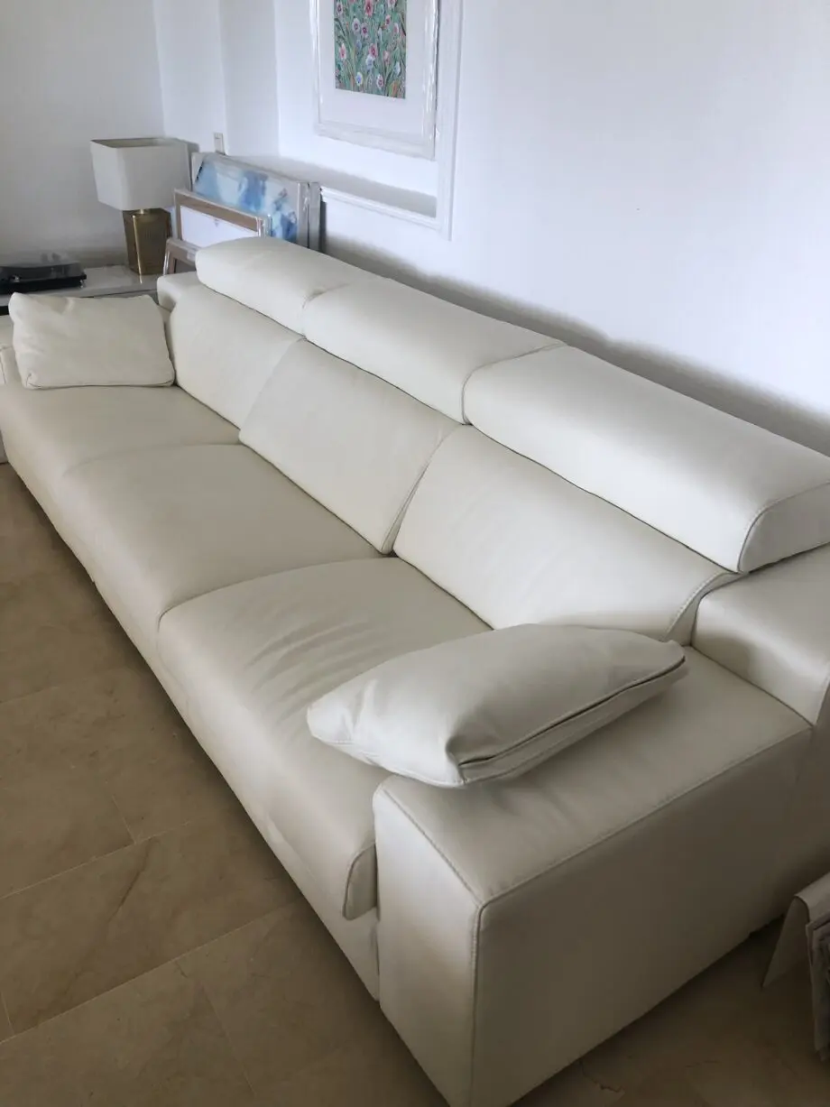 Two white leather three-seater sofas and matching reclining armchair
