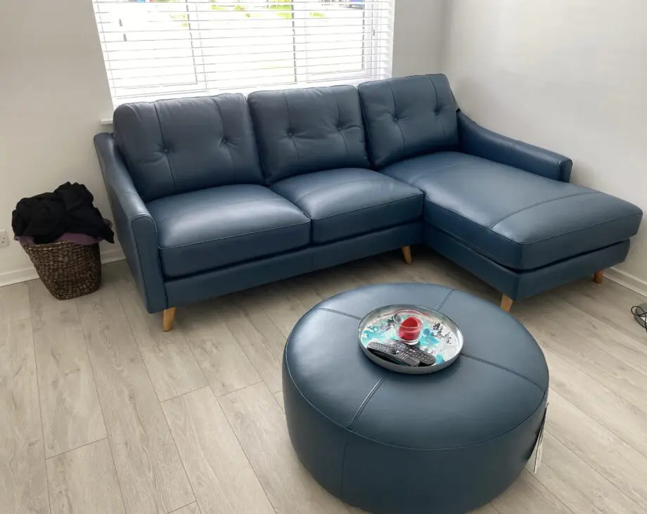 Blue leather sofa and matching footstool