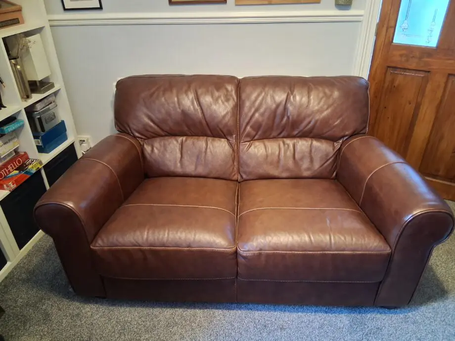 2 Dark brown DFS leather sofas plus foot stall with storage inside.